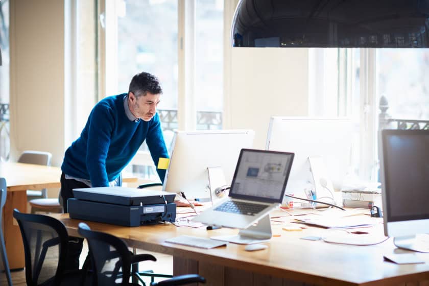 MS_teams_Video_1 Man leaning in and looking into the computer. He is invested in his work.