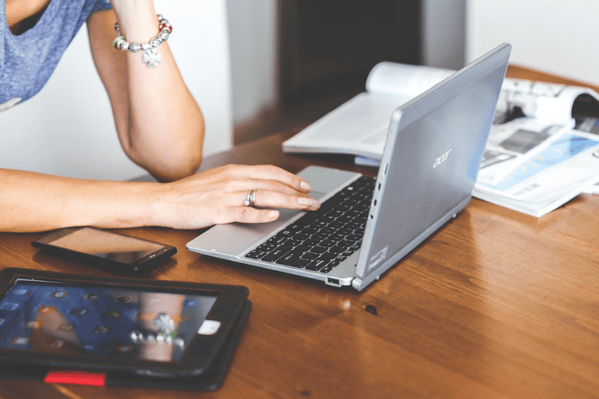 client-boundaries A person on their laptop surrounded by a phone, tablet and books