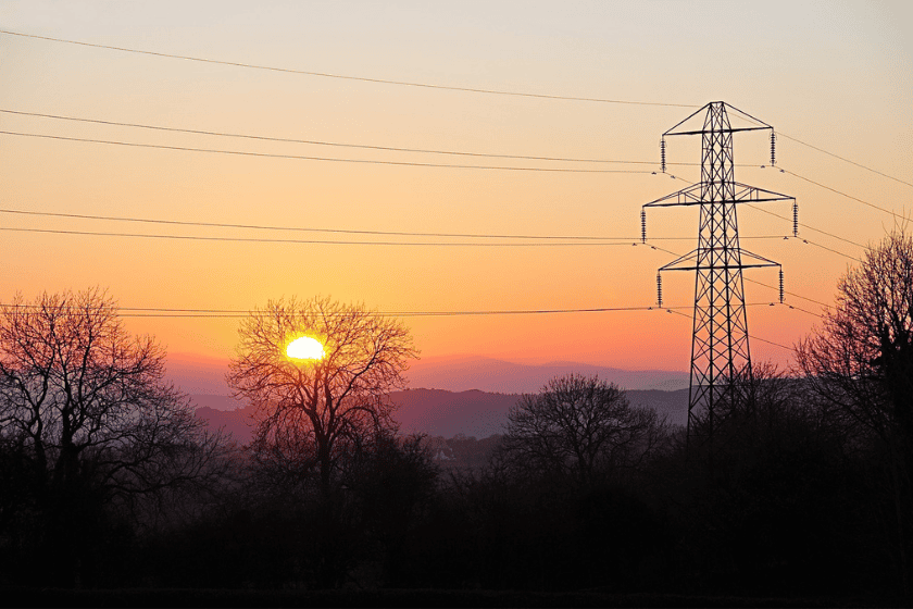 A lone transmission tower in Snowden Wales with power lines stretching across the sky