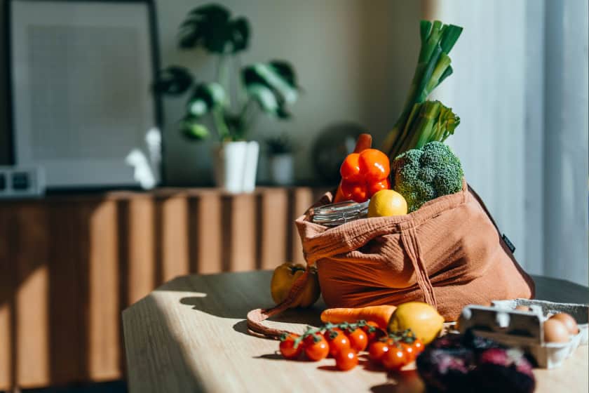 vegetablesandfrutisinasack Vegetables and fruits in a sack on a table.