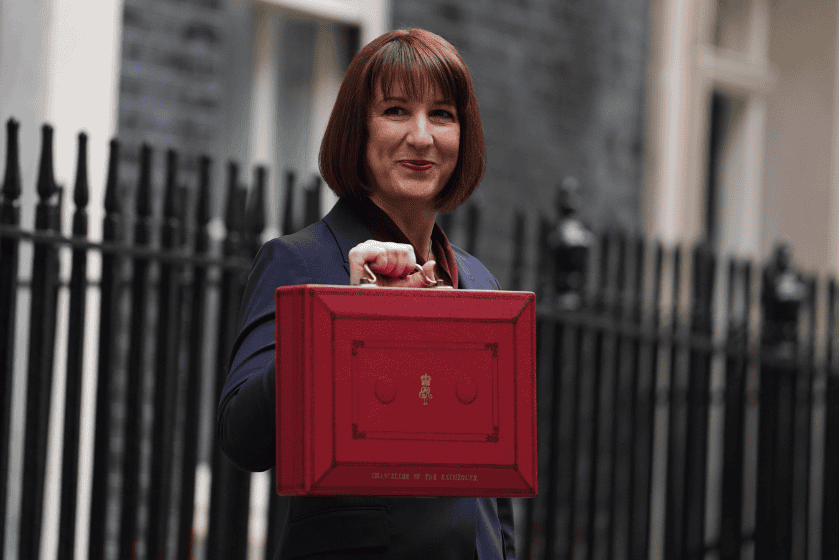 Rachel Reeves holds a red briefcase in the air
