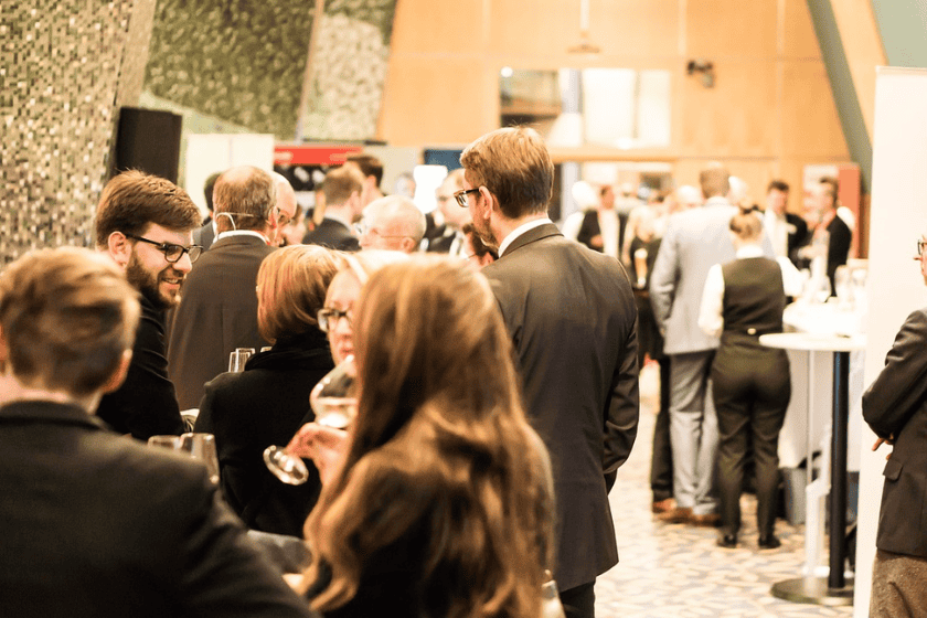 Professionals milling around in groups at a conference
