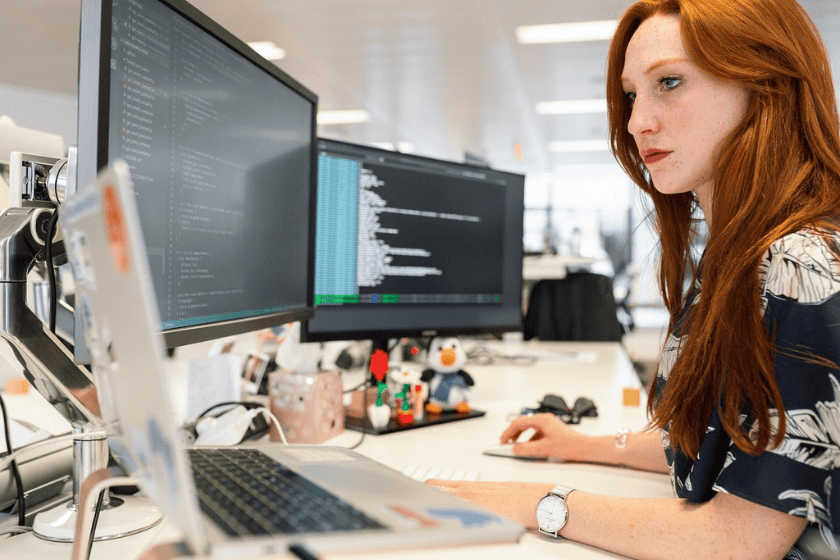 A woman looks at a computer screen in an office